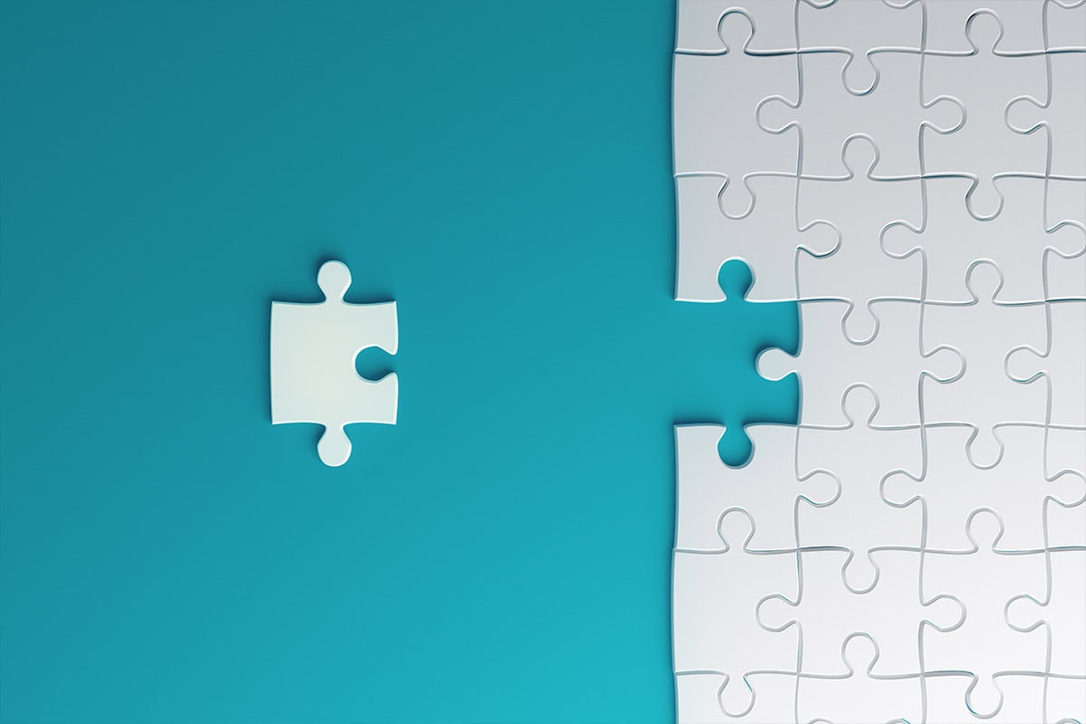 Une pièce de puzzle à côté d’un puzzle assemblé